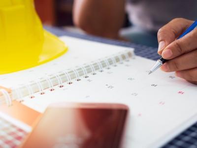 Construction project manager marking important dates on a calendar